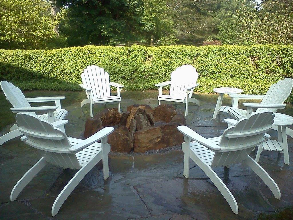 Stone fire pit with Adirondack chair seating